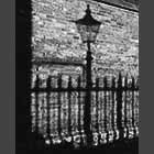 monochrome photo of the shadow of a lampost on the wall of Senate House Passage