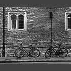 black and white photo of Two bicycles against wall of Trinity College