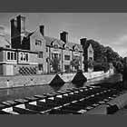 monochrome photo of punts in front of Magdalene College